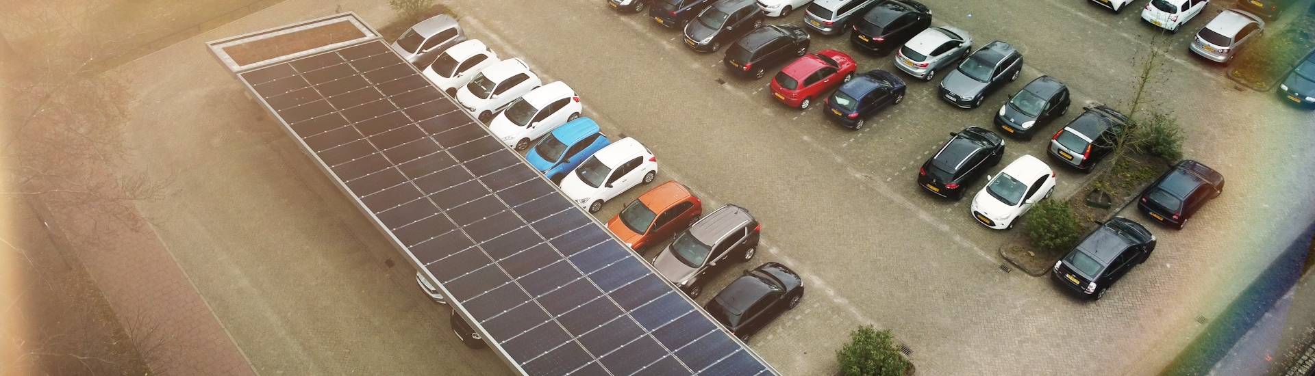 Parkeerplekken zijn overdekt met zonnepanelen, een batterij staat naast de parkeerplaats om opgewekt